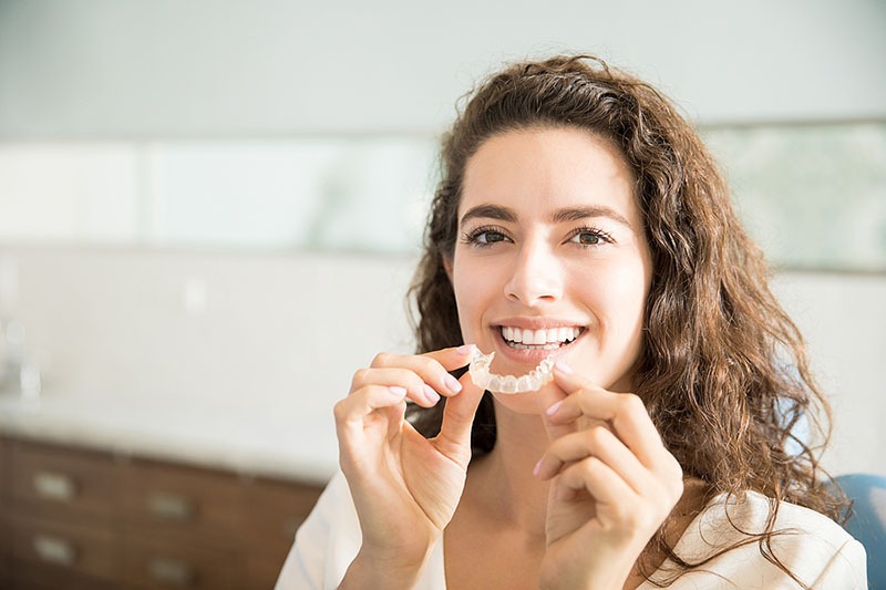 Patient smiling holding a retainer